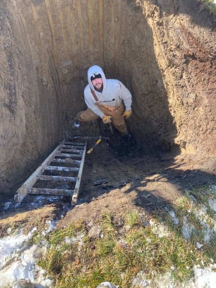 A Thompson Trenchless and Hydro Jetting worker readies for pipe repair, showing expert prep in a winter yard environment.