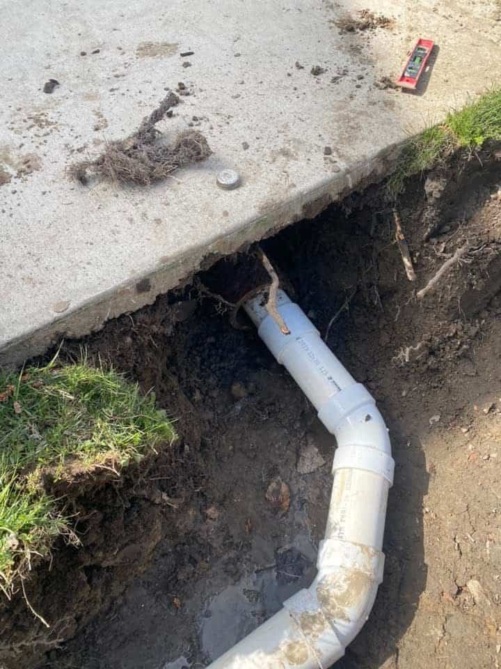 Thompson Trenchless and Hydro Jetting repairs a broken pipe beneath a sidewalk, showing clear work in progress.