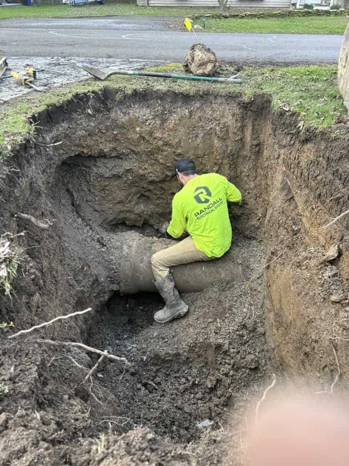 A Thompson Trenchless and Hydro Jetting worker repairs a pipe underground, showing their skill fixing tough plumbing problems.