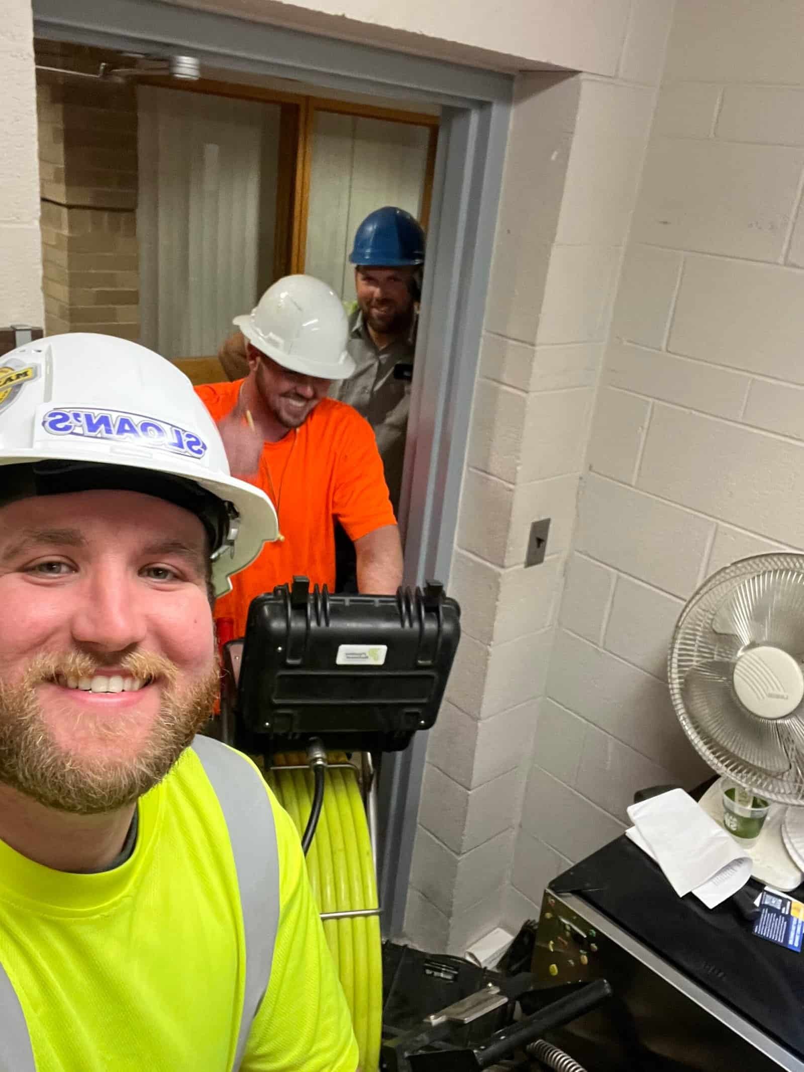 Thompson Trenchless and Hydro Jetting team smiles at work, showing pride in their pipe inspection and cleaning job.