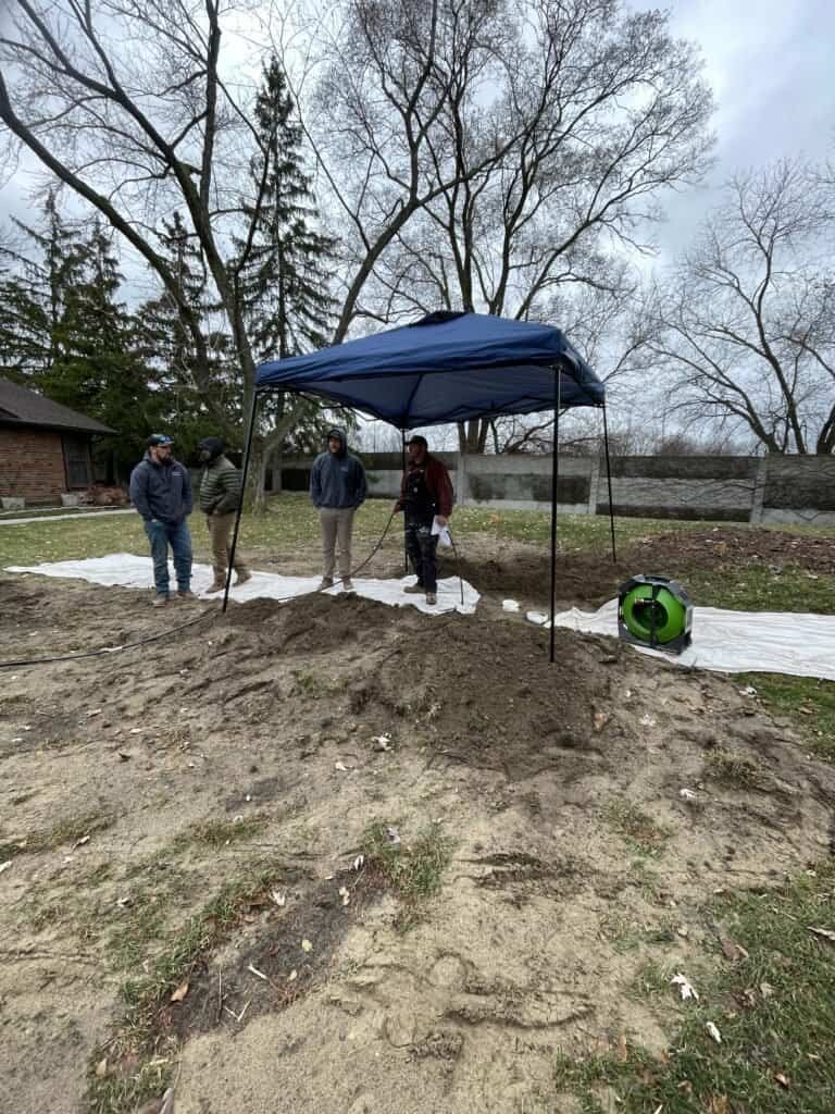 Thompson Trenchless and Hydro Jetting crew repairs sewer lines, working together outdoors using safe tools and teamwork.