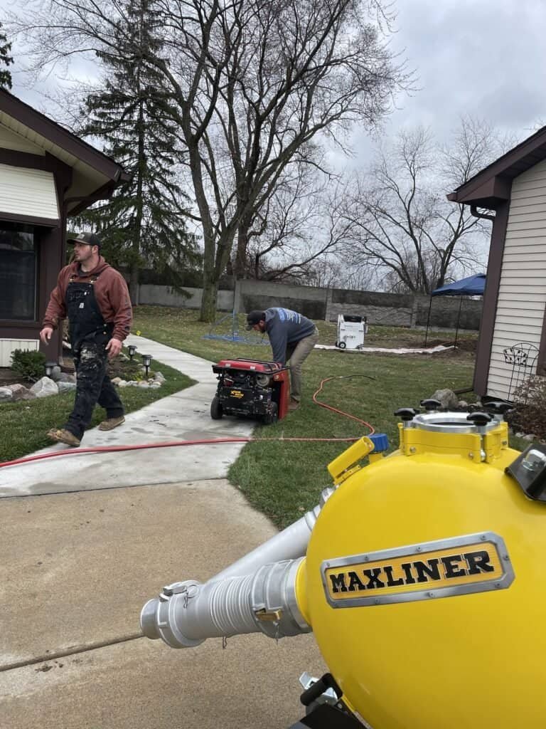 Thompson Trenchless and Hydro Jetting crew prepares equipment outside a home for sewer line repair work.