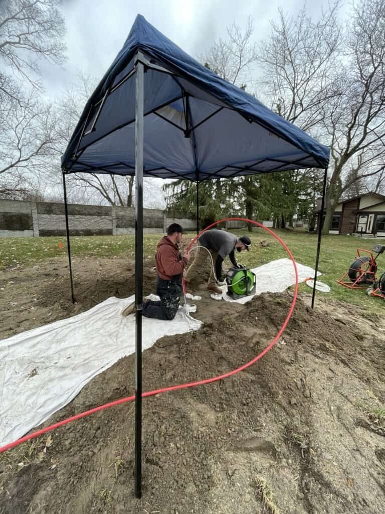 Thompson Trenchless and Hydro Jetting team fixes sewer lines outdoors, showing their equipment and tools in use.