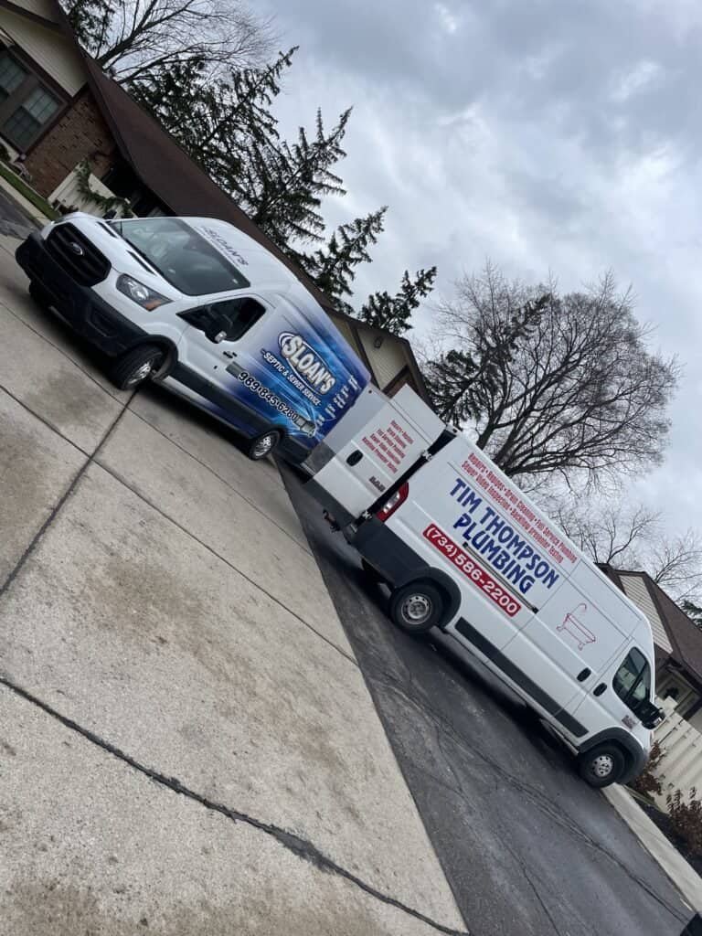 Thompson Trenchless and Hydro Jetting vans ready to help with home plumbing repairs are parked in a neighborhood driveway.