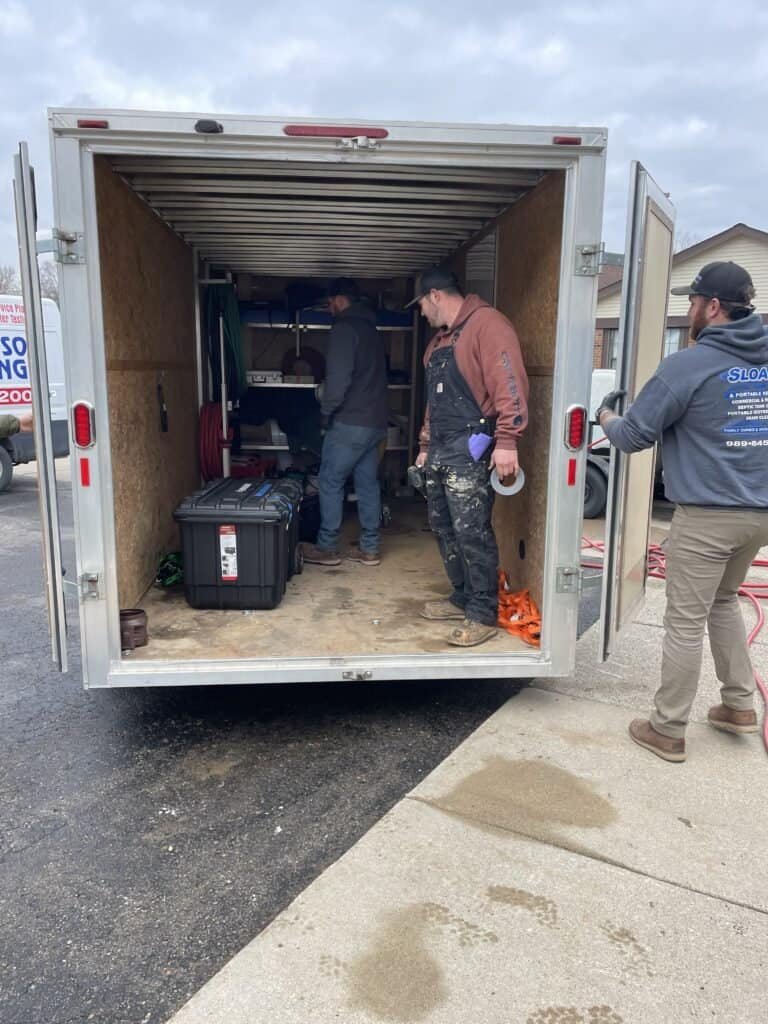 Thompson Trenchless and Hydro Jetting crew prepares pipe inspection tools together, showing teamwork before starting a job.