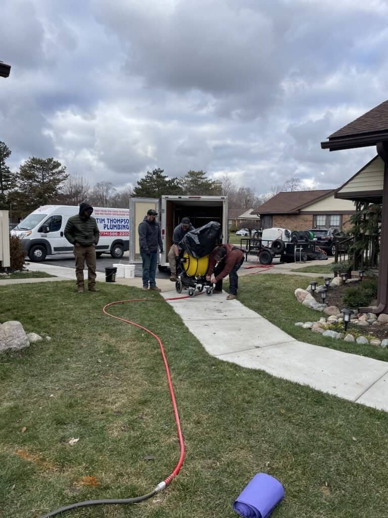 Thompson Trenchless and Hydro Jetting crew prepares to fix pipes in a neighborhood, showing readiness for their job.