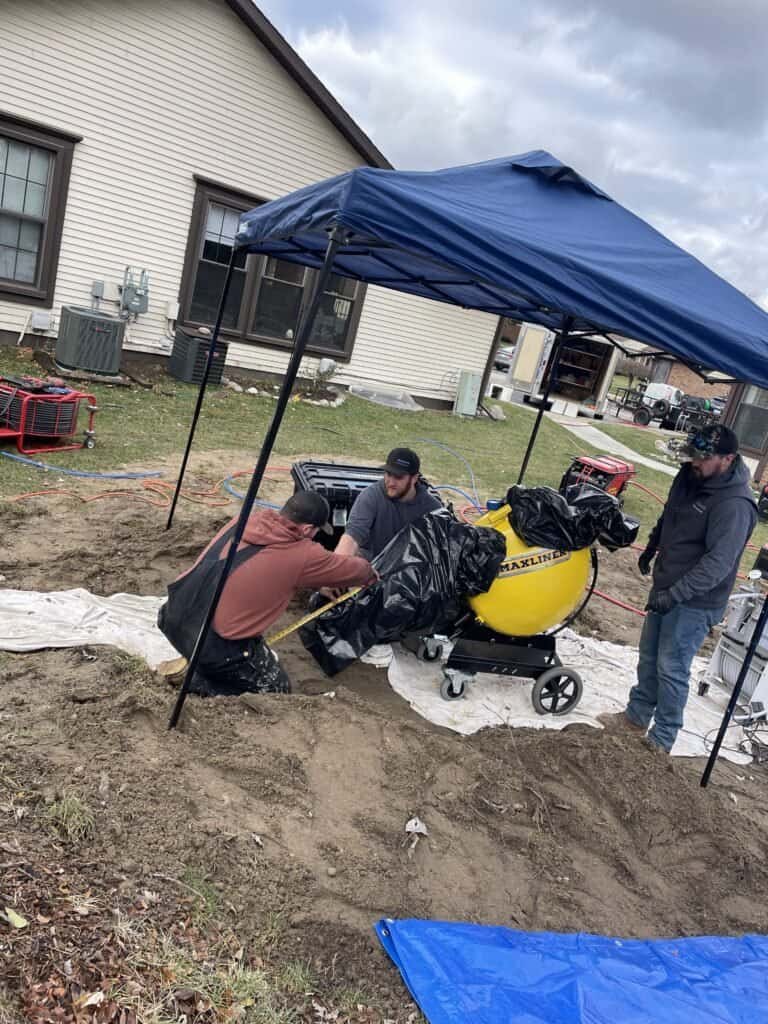 Thompson Trenchless and Hydro Jetting team repairs sewer lines in a yard, using equipment to ensure safe, reliable service.