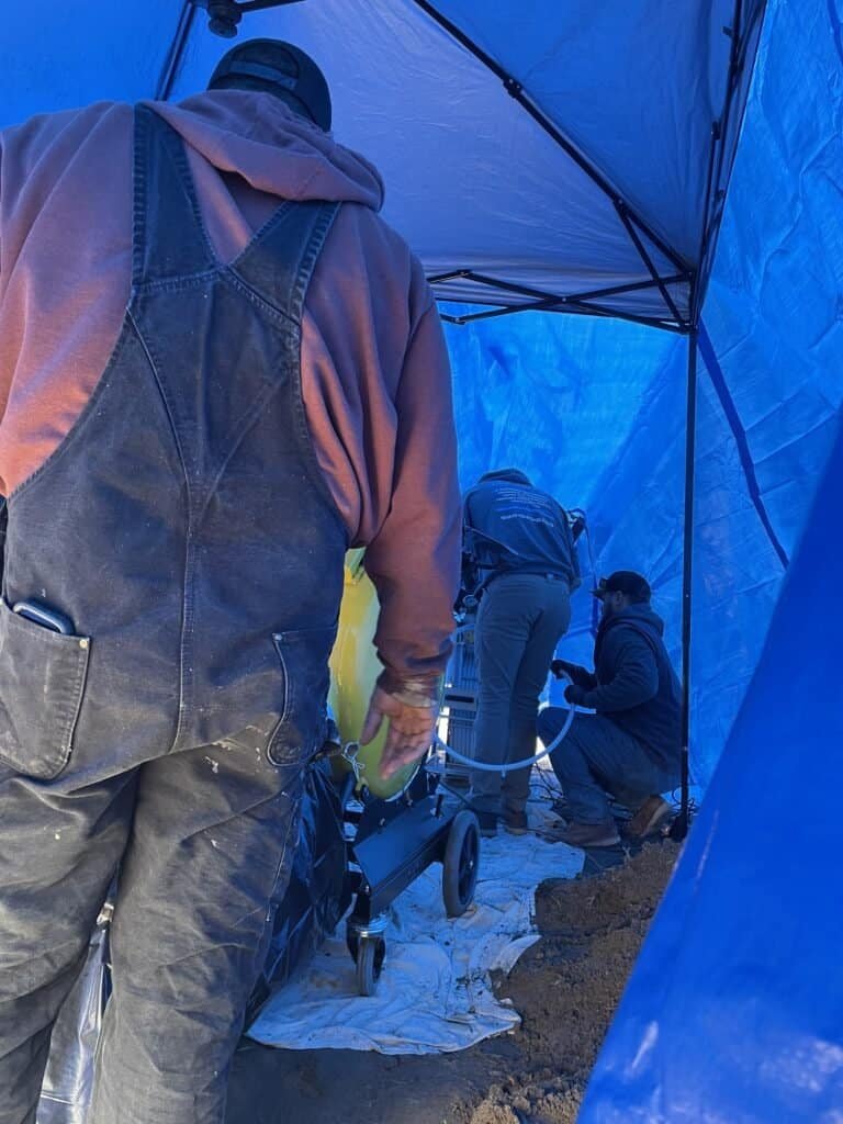 Thompson Trenchless and Hydro Jetting crew works together using equipment to repair sewer lines at a job site.