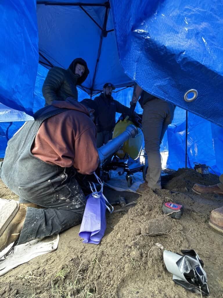 Thompson Trenchless and Hydro Jetting team works together to fix sewer pipes, showing teamwork and repair in progress.