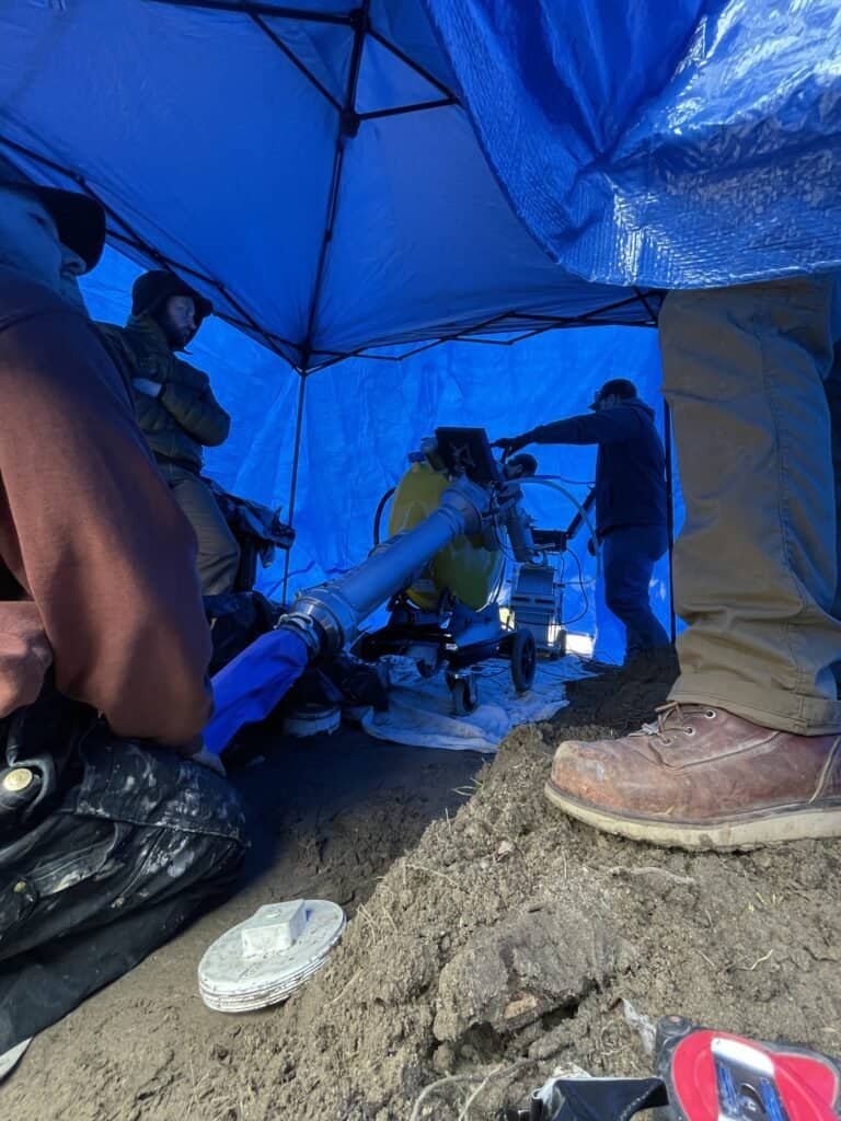 Thompson Trenchless and Hydro Jetting team repairs sewer lines, working together to handle a tough plumbing job.