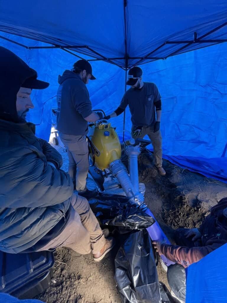 Thompson Trenchless and Hydro Jetting crew fixes sewer lines outdoors using special tools for pipe repair solutions.