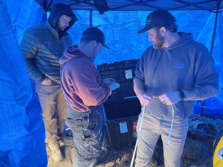 Thompson Trenchless and Hydro Jetting team is working together on a sewer repair project at an outdoor site.