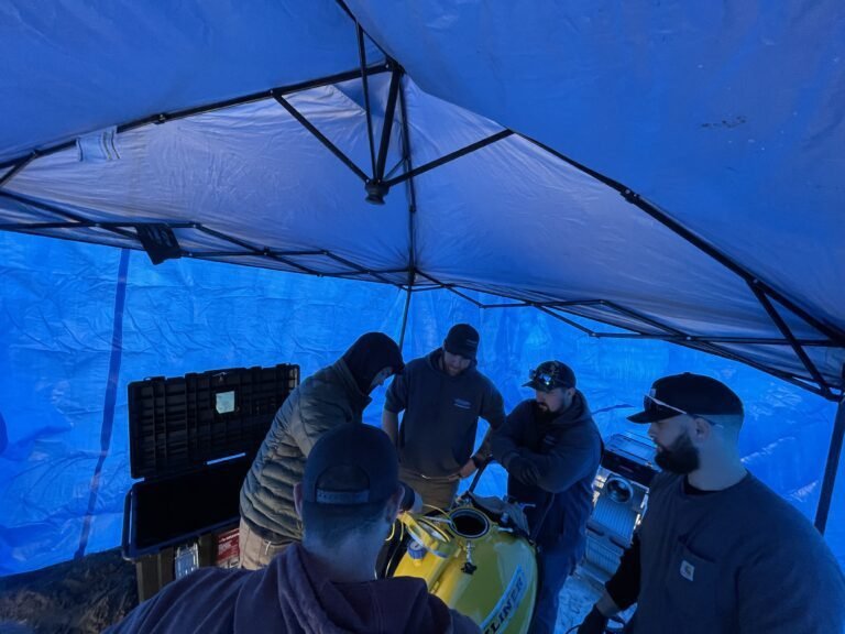 Thompson Trenchless and Hydro Jetting crew talks about a repair job, showing teamwork and service at an outdoor work site.