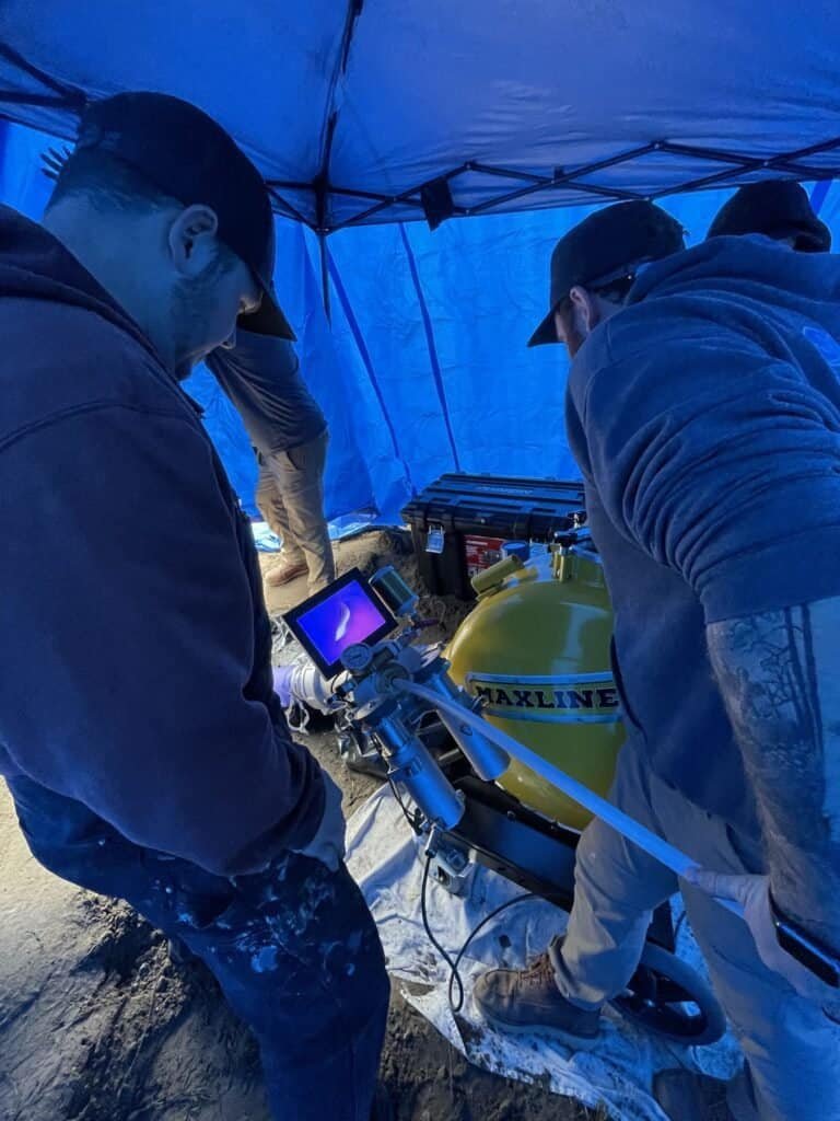 Thompson Trenchless and Hydro Jetting team checks equipment to make sure a pipe repair project is running correctly.