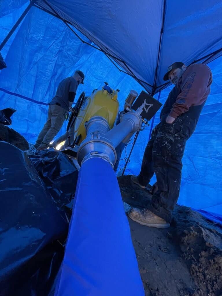 Thompson Trenchless and Hydro Jetting team repairs pipes outdoors, showing expert help for pipe or drain problems.