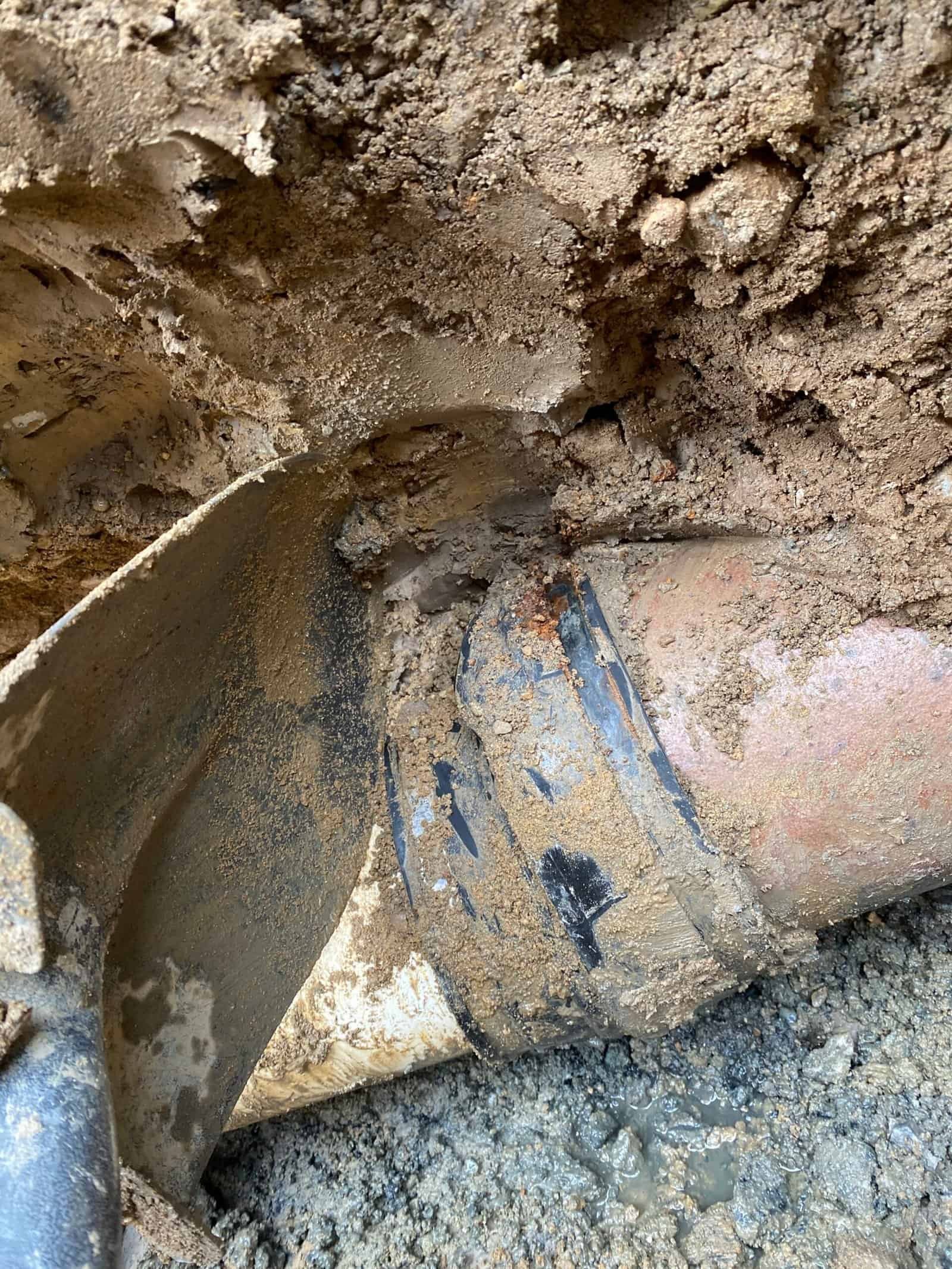 Thompson Trenchless and Hydro Jetting finishing a pipe check; wet dirt shows where underground repairs were made.