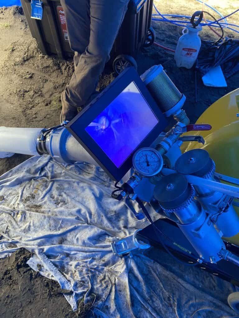 Thompson Trenchless and Hydro Jetting team member checks pipe inspection equipment to ensure safe, accurate work.