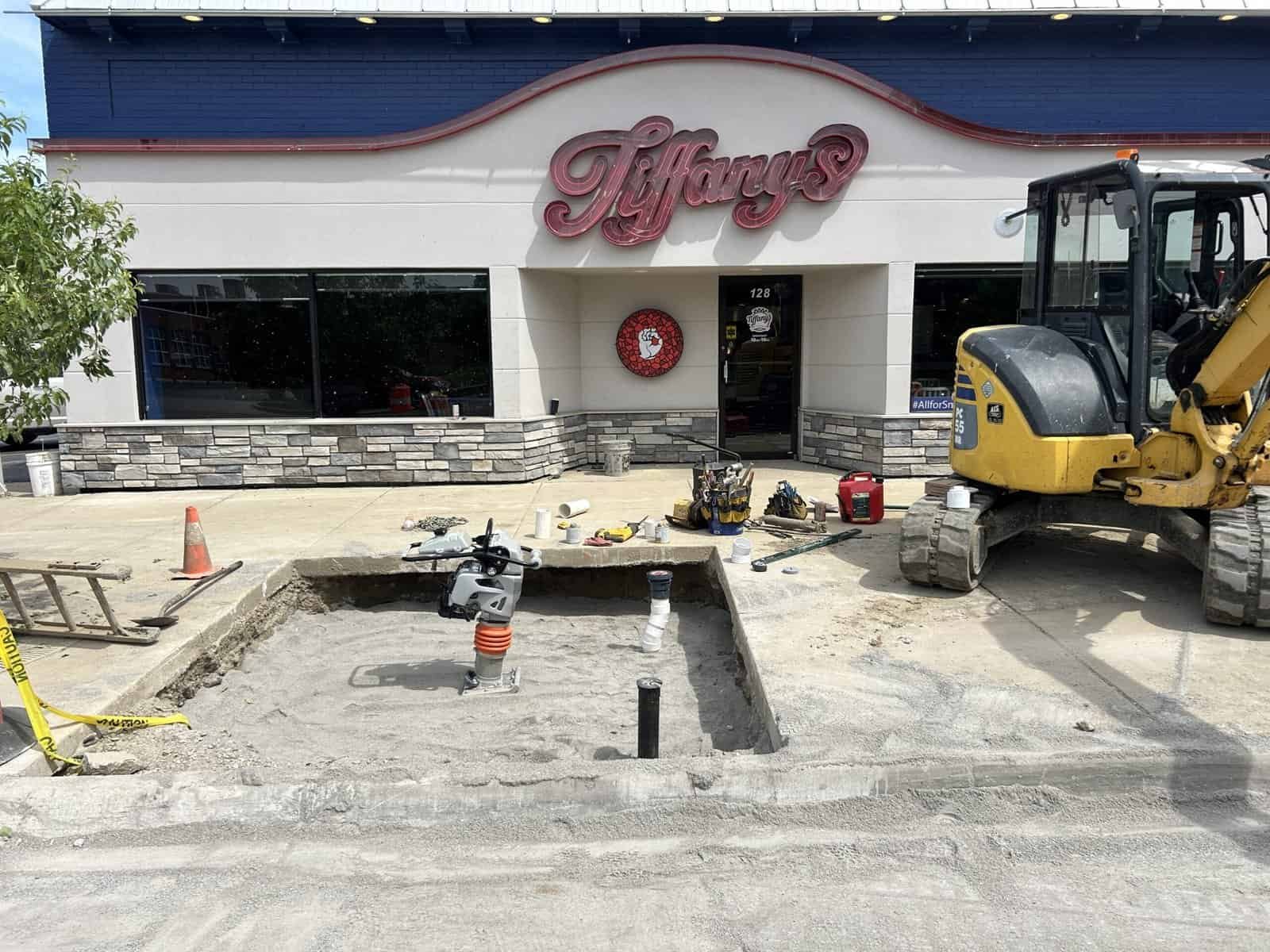 Thompson Trenchless and Hydro Jetting repairs sewer lines outside a building, showing their work in progress.
