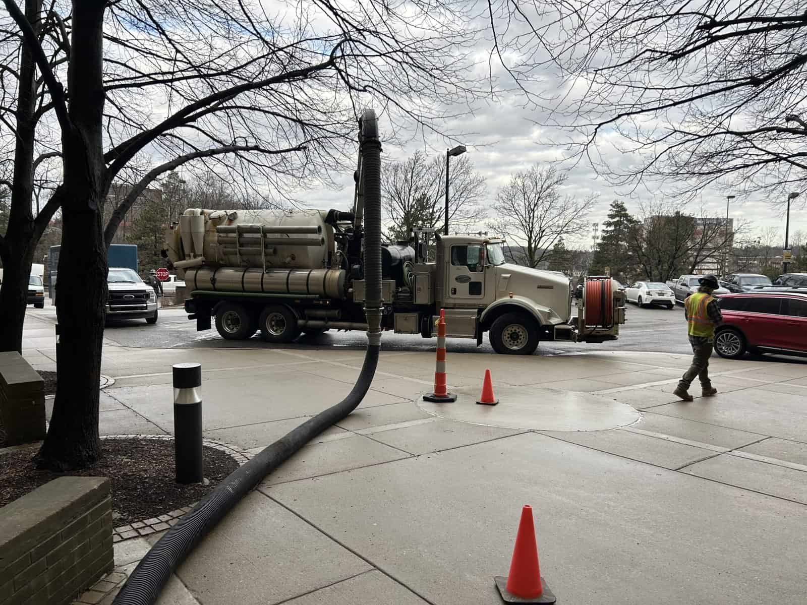 Thompson Trenchless and Hydro Jetting at work, safely cleaning pipes on a street with a crew and equipment in use.