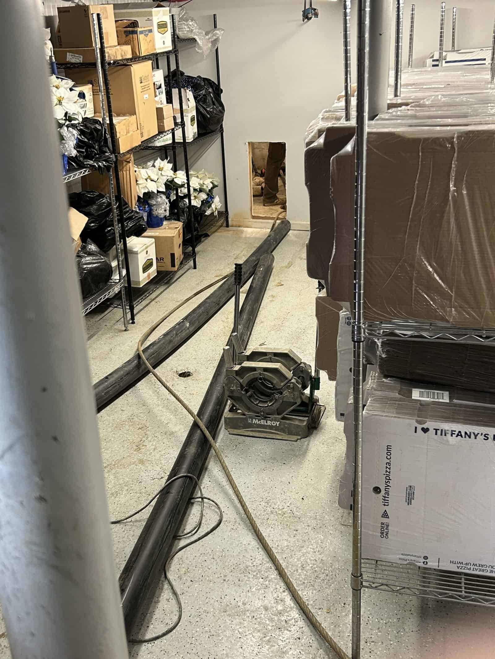 Thompson Trenchless and Hydro Jetting is working in a damp storage room to fix sewer lines and improve safety.