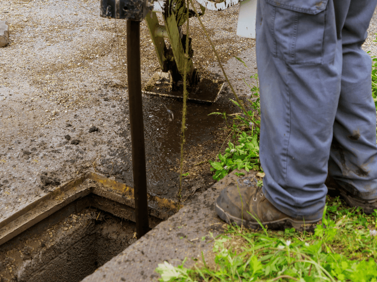 A Thompson Trenchless and Hydro Jetting worker uses equipment to clean a clogged sewer, helping keep water lines clear.