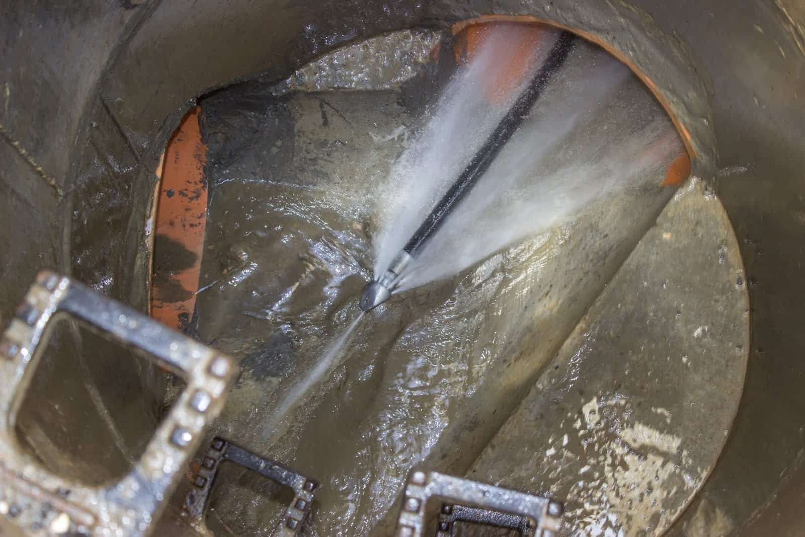 Thompson Trenchless and Hydro Jetting is shown clearing a clogged pipe with strong water jets for pipe cleaning.