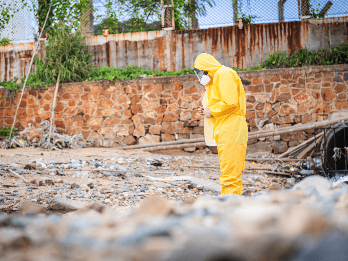 Thompson Trenchless and Hydro Jetting worker inspects a beach for safe cleanup before pipe or jetting work begins.