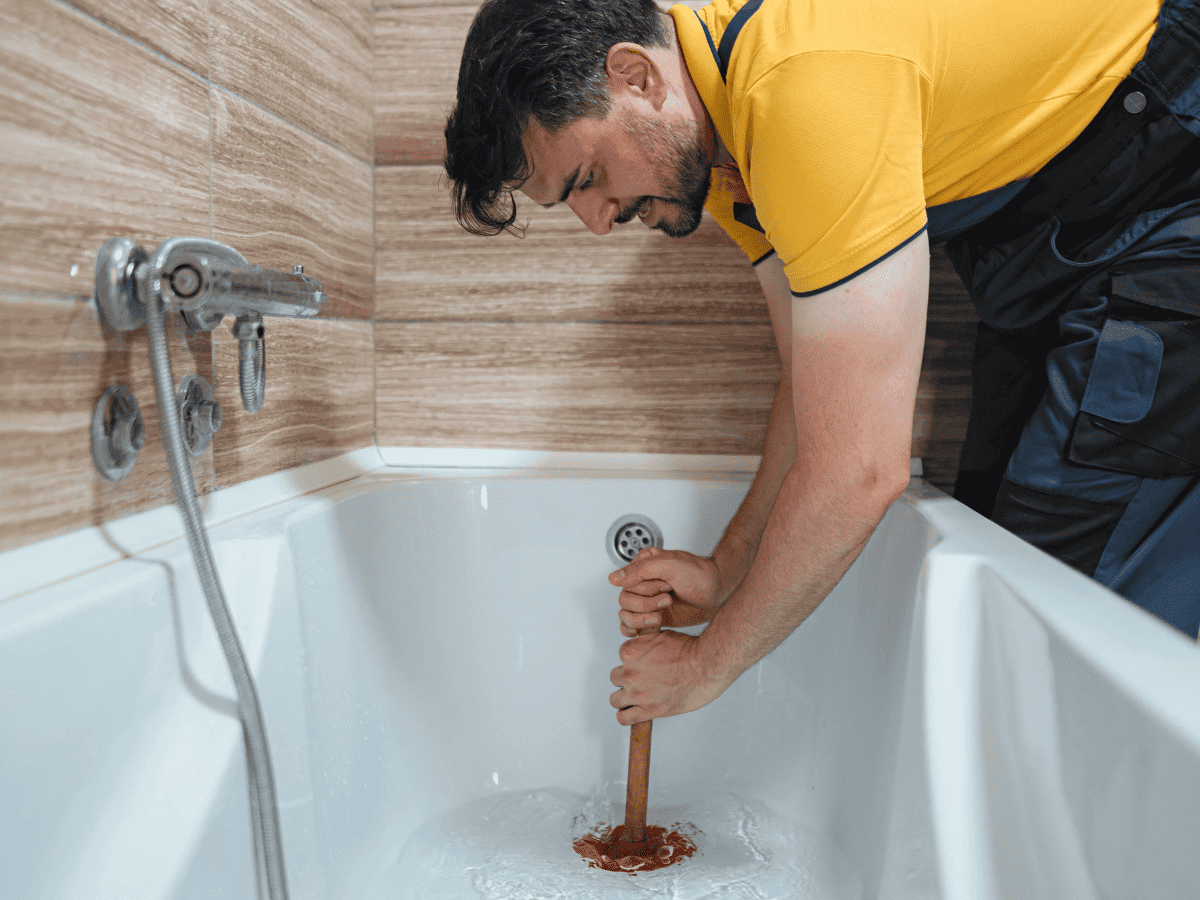 A person tries to fix a clogged bathtub and thinks about calling Thompson Trenchless and Hydro Jetting for lasting help.