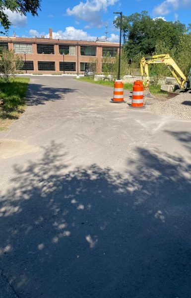 Thompson Trenchless and Hydro Jetting is repairing pipes, with road work showing safe, professional service in progress.