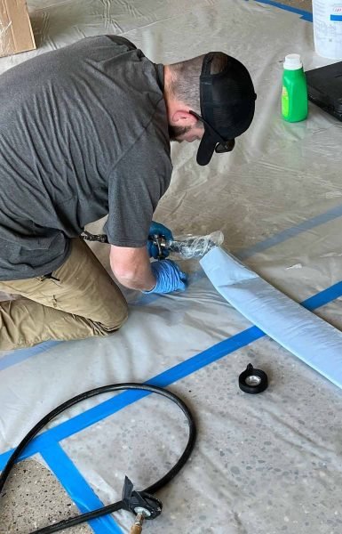 A Thompson Trenchless and Hydro Jetting worker gets equipment ready for a cleaning job, following safety steps carefully.