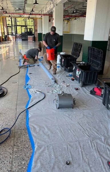 Thompson Trenchless and Hydro Jetting team gets ready to fix sewer lines safely in a bright, organized work area.