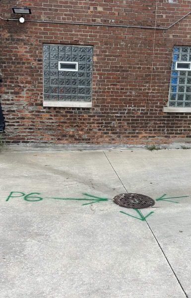 Thompson Trenchless and Hydro Jetting working near a marked manhole, showing where sewer work is needed by the building.