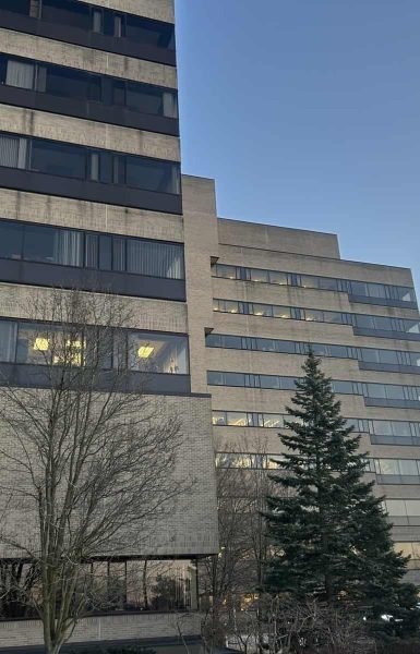 Thompson Trenchless and Hydro Jetting vehicles are ready for service near a large office building at sunset.