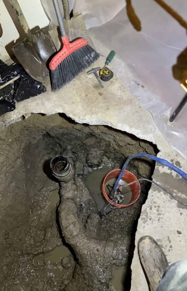 Thompson Trenchless and Hydro Jetting is repairing a damaged sewer line, showing tools and signs of active work on site.