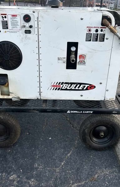 Thompson Trenchless and Hydro Jetting’s machine is set up for cleaning work, with a worker nearby in a safety vest.