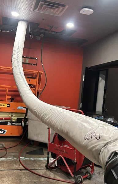 Thompson Trenchless and Hydro Jetting fixing leaks in a room with water on the floor, using special tools for pipe repair.