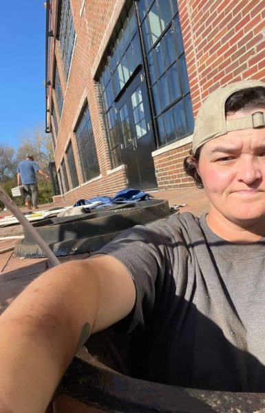 Thompson Trenchless and Hydro Jetting team is on site, making pipe repairs outside a building on a sunny day.