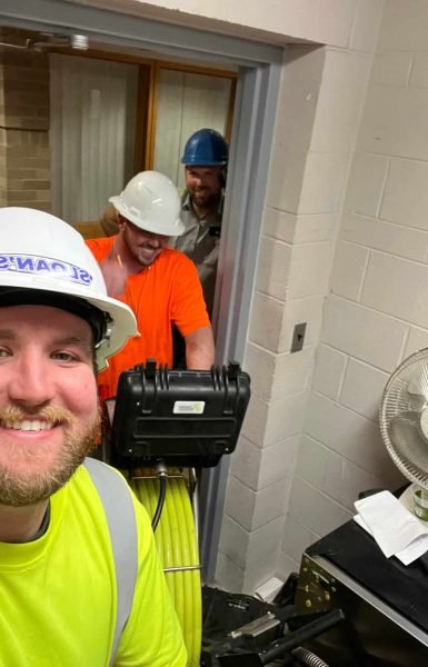 Thompson Trenchless and Hydro Jetting workers show teamwork and pride while on the job inside a building.