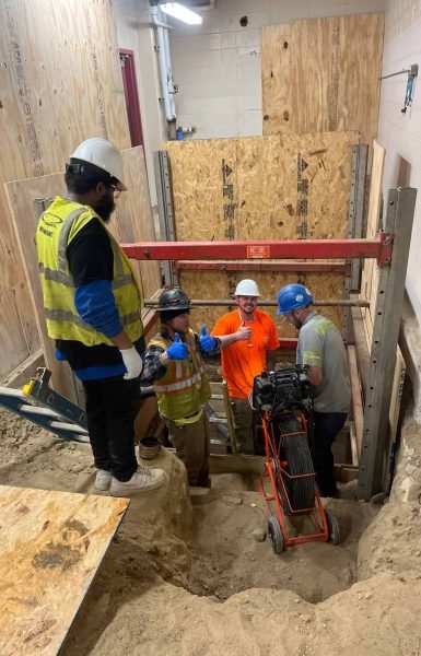 Thompson Trenchless and Hydro Jetting team inspects pipes together, showing teamwork and job confidence.