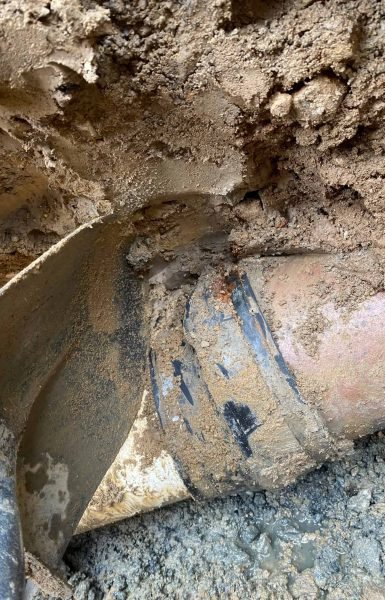 Thompson Trenchless and Hydro Jetting fixing a sewer line in wet ground, showing careful repair work in progress.