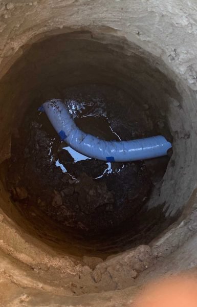 Thompson Trenchless and Hydro Jetting checking a well with a pipe for water or sewer line repair.