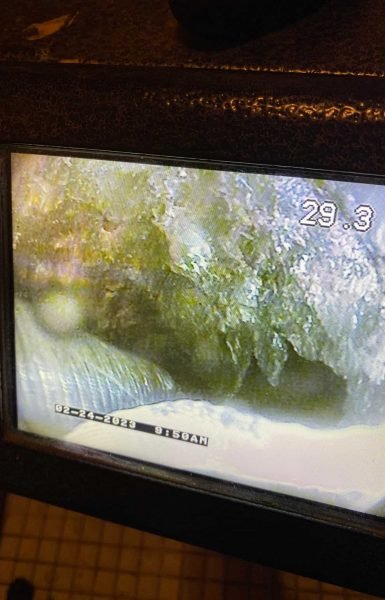 Thompson Trenchless and Hydro Jetting pipe inspection shows buildup in a drain, with distance and date on the screen.