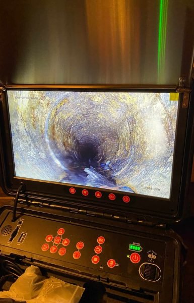Thompson Trenchless and Hydro Jetting staff view pipe interiors on a screen to check for damage during sewer inspections.
