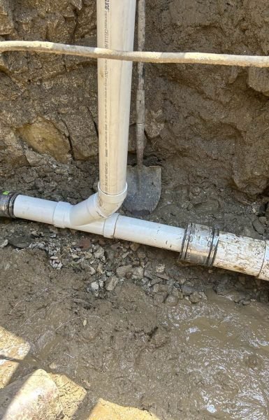 Thompson Trenchless and Hydro Jetting shows a pipe repair job in progress with work tools and loose soil at the site.