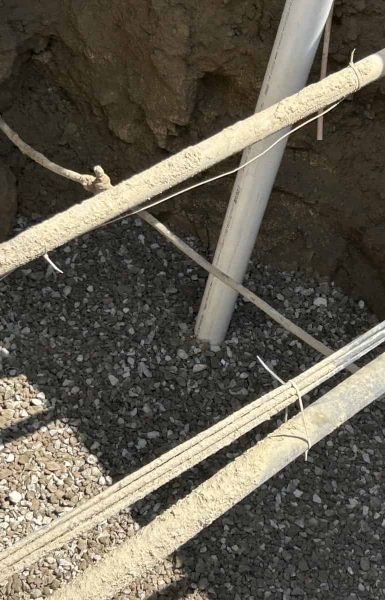 Thompson Trenchless and Hydro Jetting works on underground pipes, showing careful repair in a sunny trench area.